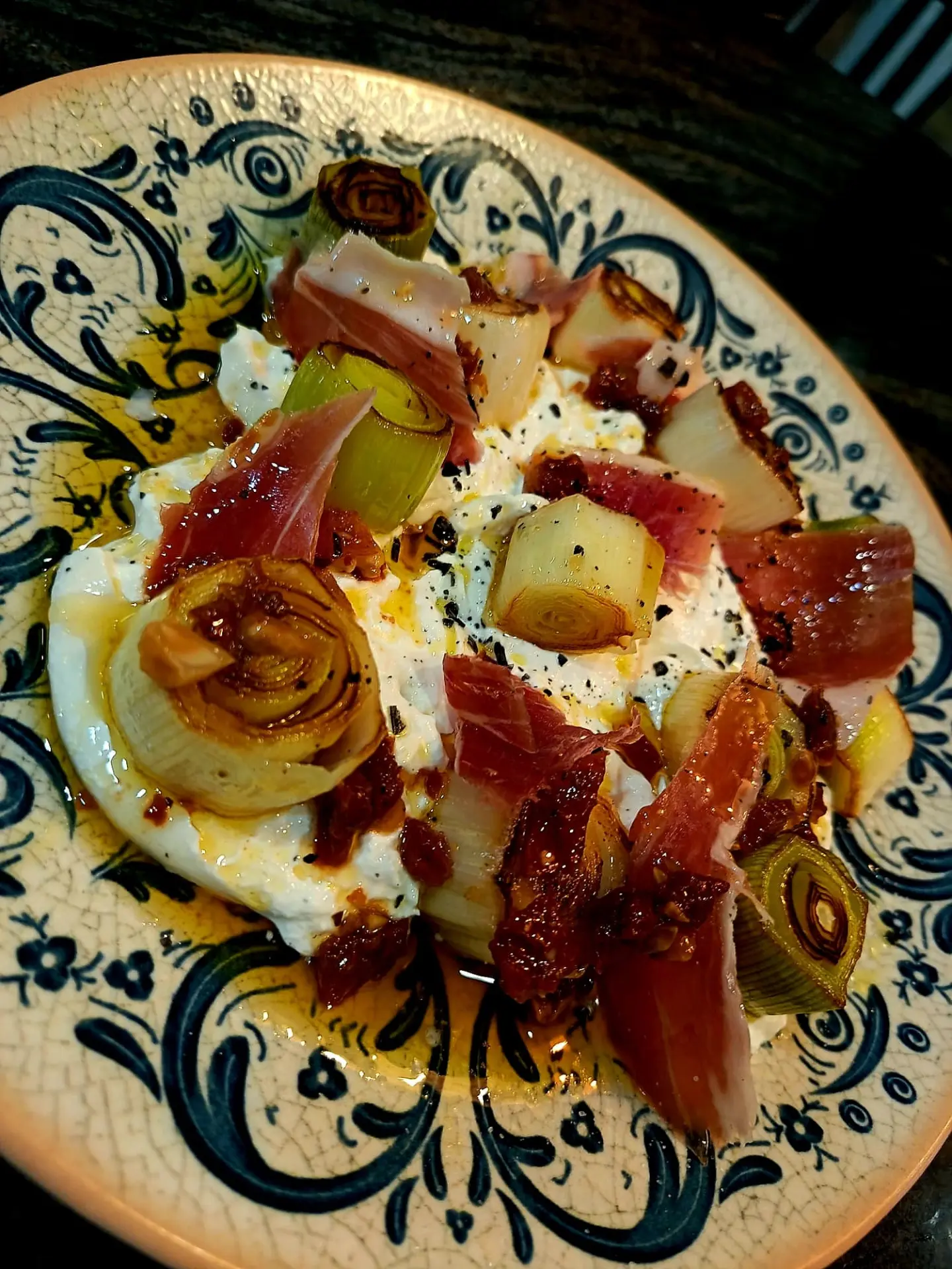 Burrata con puerro asado, jamón y tomate seco servida en loza artesanal en D'Luca Gastrobar