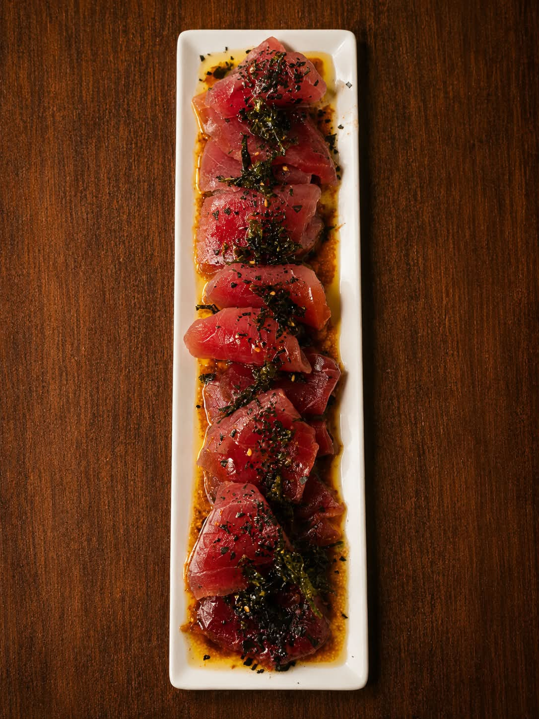 Tataki de atún rojo de almadraba con alga nori y aliño de soja y aceite en plato alargado